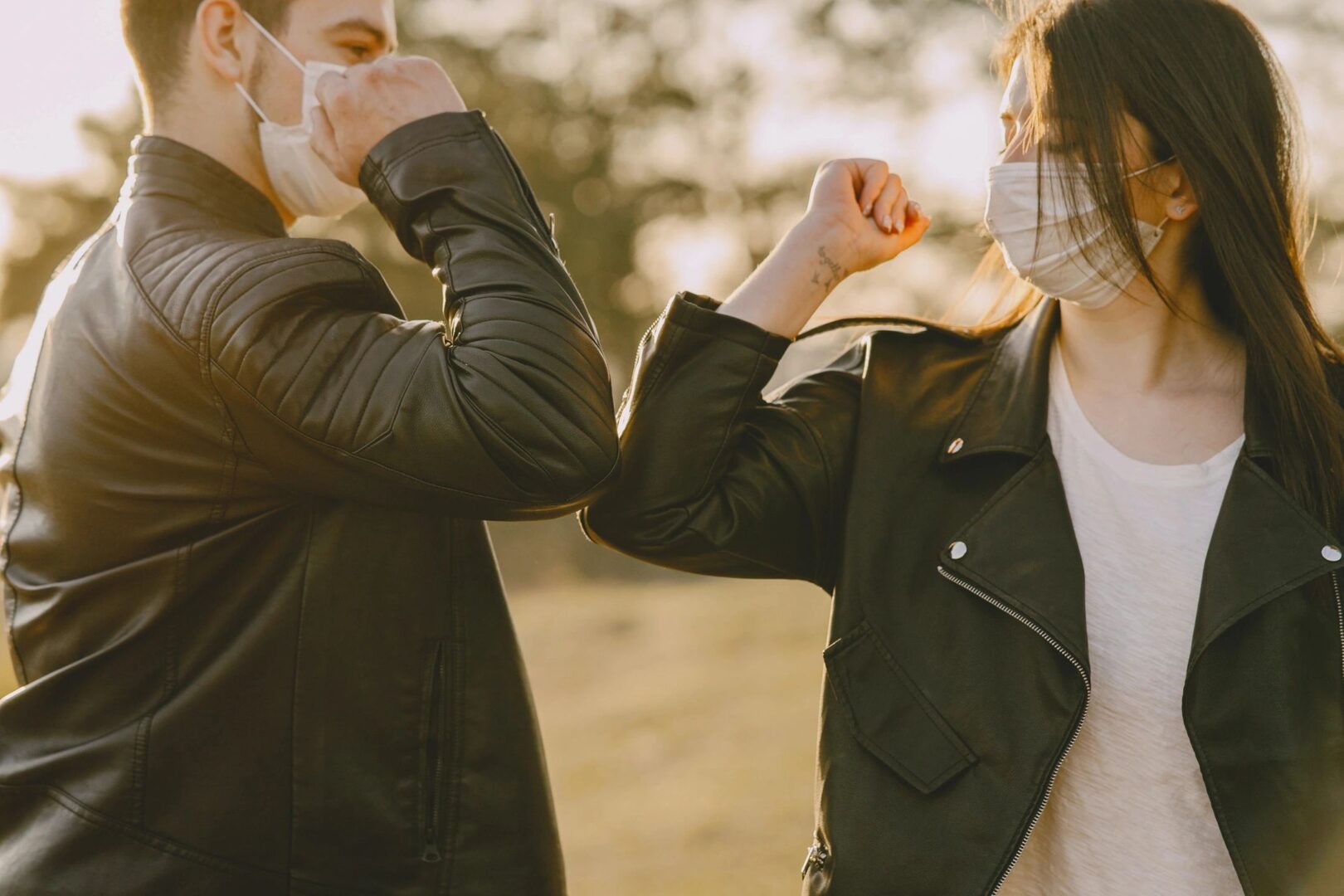 Two people in leather jackets arm wrestling.